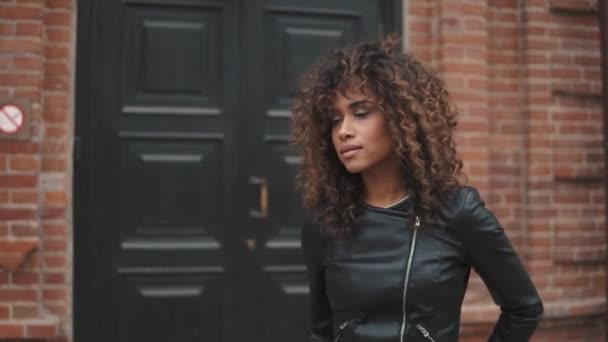 Portrait of a girl with a beautiful make-up and curls on a background of old architecture — Stock Video