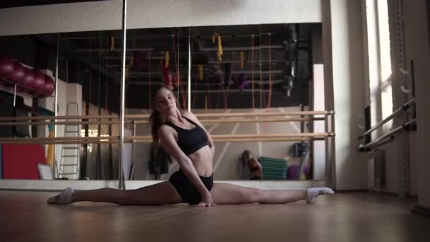Σπορ κορίτσι κάνει διαιρέσεις στο γυμναστήριο. αργή κίνηση — Αρχείο Βίντεο