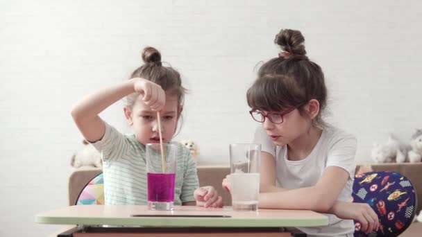 Vorbereitung auf das Experiment. Kinder spielen im Labor. Kleines Mädchen rührt chemische Reagenzien in Glas — Stockvideo