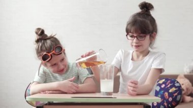 komik çocuk kimyasal bir deney yapmak ve reaktifler karıştırın. çocuklar ve mutlu kimyasal reaksiyon izlerken