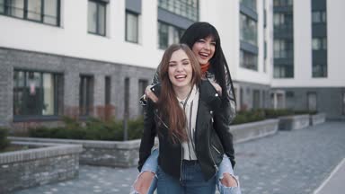 Sırtımda gülüyor ve şehir üzerinde yürüyüş tatil veren kızlar genç arkadaşlar yazında gezi. yavaş Scene