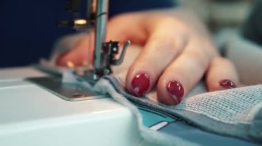 kadın bir dikiş makinesi diker. Eller yukarı