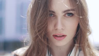 yakın çekim portre mavi gözlü bir kız. Rüzgar sarışın saç çırpınır. ağır çekim