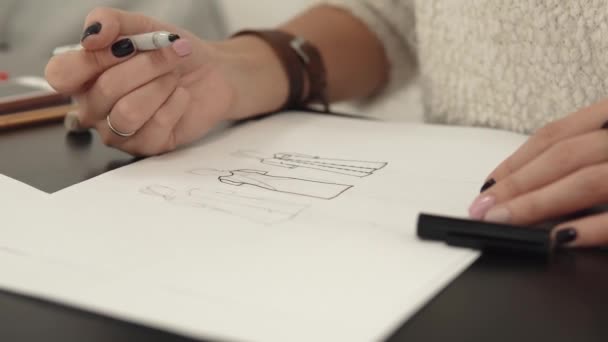 Σχεδιαστής ρούχων κάνει ένα περίγραμμα από τα ρούχα με μια αισθητή-πένα tip. κοντινό πλάνο γυναικεία χέρια — Αρχείο Βίντεο