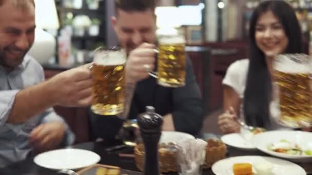 Multietnisk grupp av vänner att ha middag på ett café. ett stort företag har kul tillsammans, skratta och prata. män toast glasögon — Stockvideo