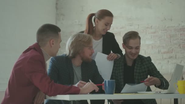 Kollegerna pratar medan de sitter vid ett bord på kontoret. kreativa team planerar ett projekt. — Stockvideo