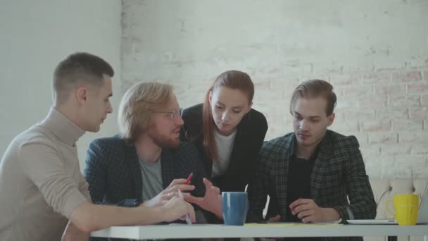 Colleghi stanno parlando mentre sono seduti a un tavolo in ufficio. team creativo sta progettando un progetto . — Video Stock