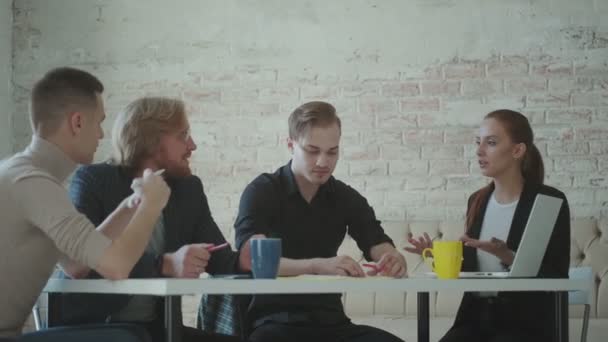 Team av unga yrkesverksamma kommunicera vid ett bord på kontoret — Stockvideo