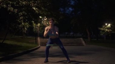 Akşam parkında egzersiz yapan genç bir kız.