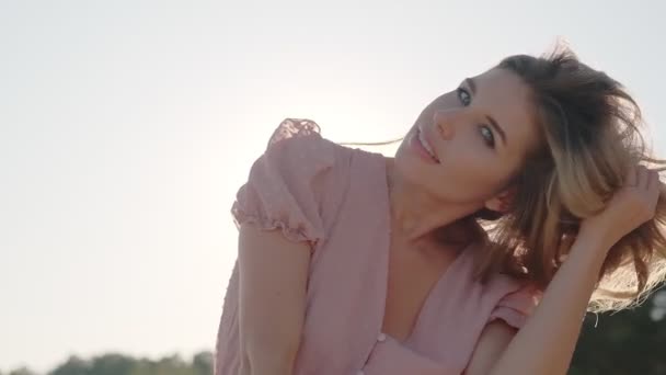 Retrato de una chica atractiva a la luz del sol. joven mujer sonriendo y posando a la cámara — Vídeos de Stock