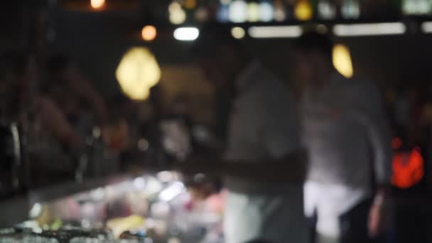 Размытые бармены работают в баре и наливают напитки в бокалы — стоковое видео