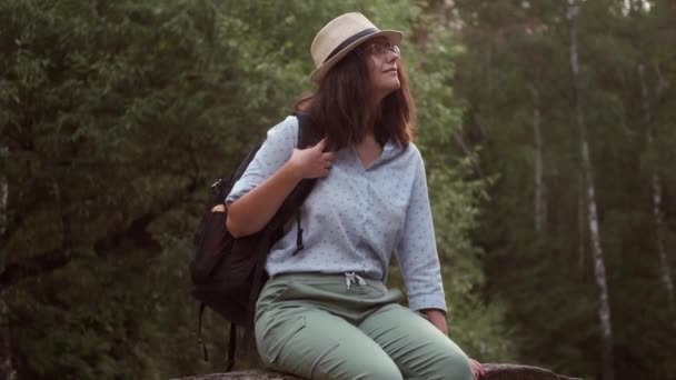 Viaggiatrice che riposa nella foresta. ritratto di una giovane turista in un cappello all'aperto — Video Stock