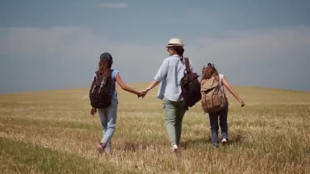 Família de viajantes corre despreocupado ao longo da colina. mãe leva seus filhos pequenos em uma caminhada — Vídeo de Stock