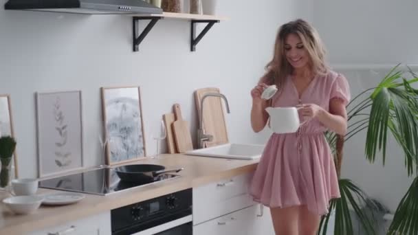 Χαρούμενο κορίτσι που ετοιμάζει πρωινό νωρίς το πρωί στην κουζίνα και χορεύει — Αρχείο Βίντεο