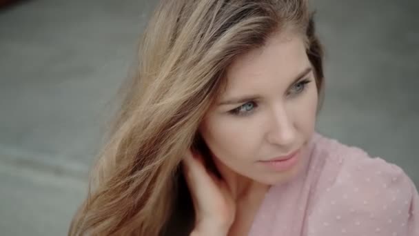 Retrato close-up de uma loira com olhos azuis brilhantes. menina posando e olhando para a câmera — Vídeo de Stock