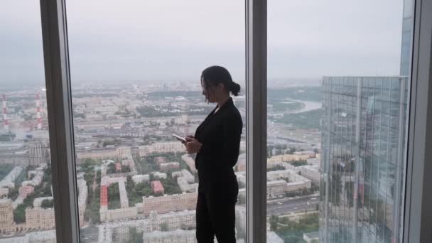 Силует ділової жінки на фоні міста — стокове відео