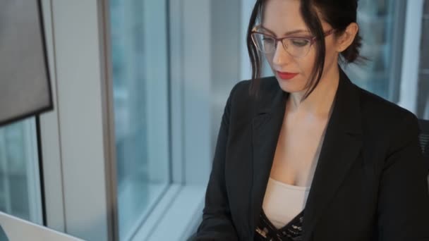 Portrait rapproché d'une jeune femme d'affaires travaillant à un ordinateur dans un bureau moderne — Video