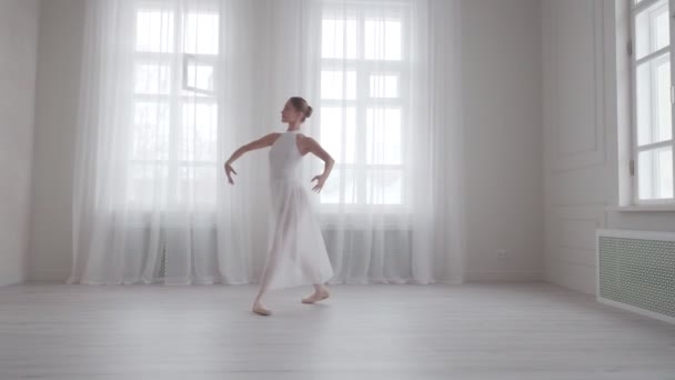 Изящная девушка танцует классический балет в ярком зале — стоковое видео