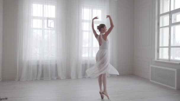 Elegante bailarina bailando y de puntillas en zapatos puntiagudos en una clase de baile brillante — Vídeo de stock