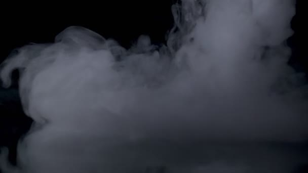 Efecto niebla. Humo atmosférico. Fondo nebuloso. Nube de humo abstracta. Humo blanco flotando lentamente a través del espacio contra fondo negro — Vídeo de stock