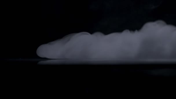 Efecto niebla. Humo atmosférico. Fondo nebuloso. Nube de humo abstracta. Humo blanco flotando lentamente a través del espacio contra fondo negro — Vídeo de stock