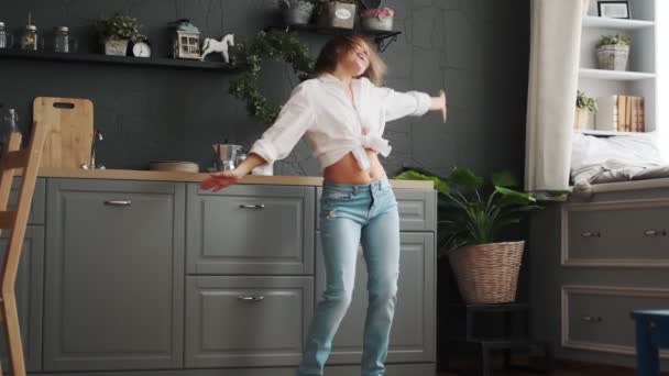 Glad kvinna rolig dans i köket och leende bekymmerslös — Stockvideo