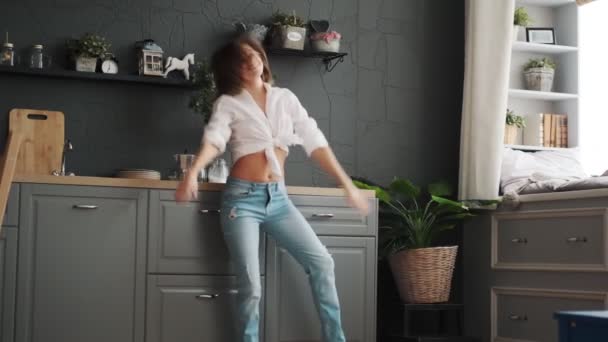 Leuk meisje is het hebben van plezier dansen in de keuken. gelukkig vrouw is dansen gek en lachen. — Stockvideo