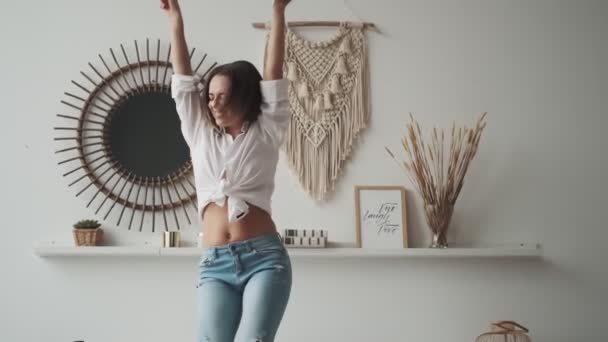 Gelukkig meisje hebben plezier dansen thuis. jonge vrouw zorgeloos dansen met opgeheven armen — Stockvideo