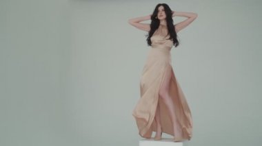 Gece elbisesi içinde rüzgarda çırpınan çekici bir kızın portresi. Güzel makyajlı ve saç stili olan genç bir kadın. Reklam parfümleri ya da diğer kavramlar için modaya uygun bir görüntü.