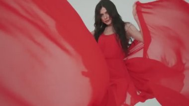 Kırmızı elbiseli tutkulu bir kadın. Ellerinde bez olan bir kız. Reklam parfümleri ya da diğer kavramlar için modaya uygun bir görüntü.