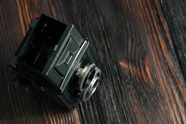 The old film camera on the old wooden table.