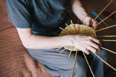 Adamın elleri bir hasır sepet yapım