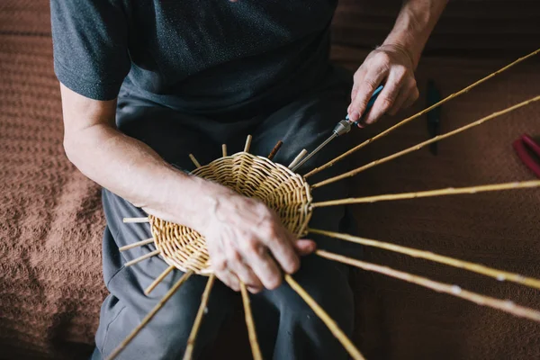 Manos de hombre haciendo una cesta de mimbre — Foto de Stock