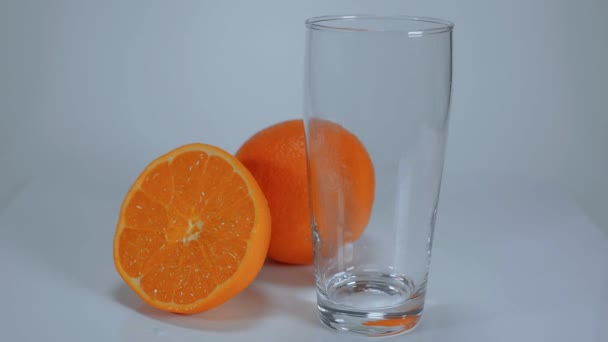 Наливание свежевыжатого апельсинового сока в стакан — стоковое видео