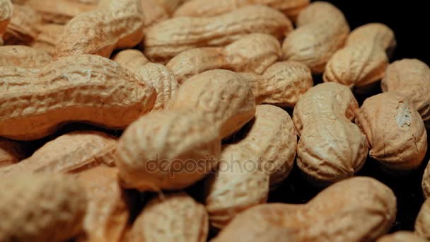 Câmera desliza sobre amendoins assados em um close-up ou macro tiro — Vídeo de Stock