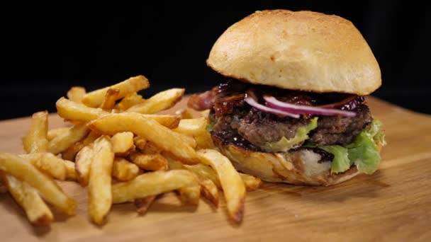 Close up de um churrasco grelhado Burger com bacon e batatas fritas — Vídeo de Stock