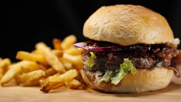 Primer plano de una barbacoa a la parrilla Hamburguesa con tocino y papas fritas — Vídeo de stock