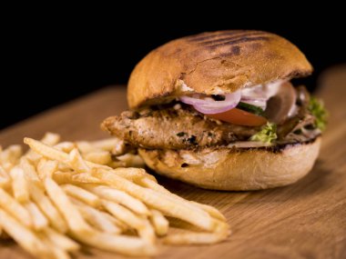 Pastırmalı kızarmış bir tavuk Burger ve patates kızartması kapat