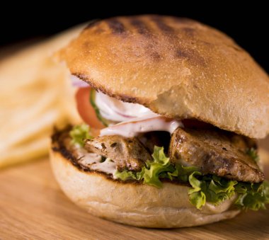 Pastırmalı kızarmış bir tavuk Burger ve patates kızartması kapat