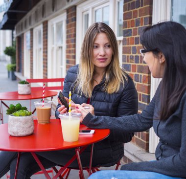 İki kız bir sokak café'de rahatla ve içki