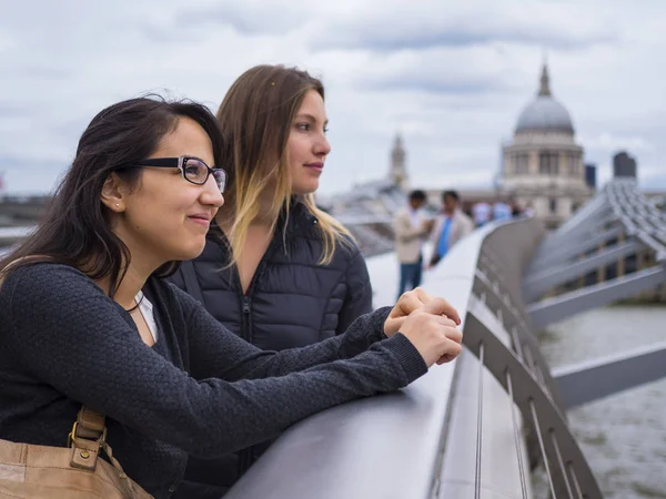 Přítelkyně na Millenium Bridge v Londýně - návštěva města, návštěva památek — Stock fotografie