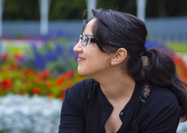 Beautiful young girl relaxes in a park — Stock Photo, Image