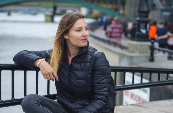 Jeune fille assise sur un mur à River Thames à Londres — Photo