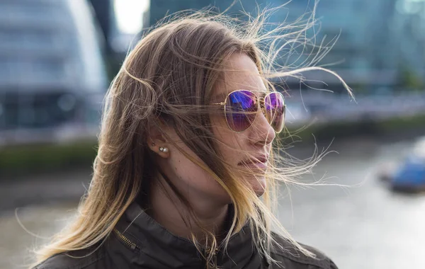 Mujer rubia joven en la ciudad de Londres en un día ventoso — Foto de Stock