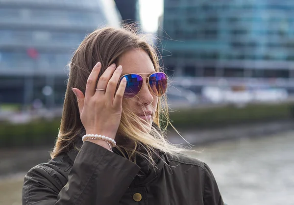 Mujer rubia joven en la ciudad de Londres en un día ventoso — Foto de Stock