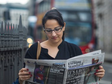 Sokakta bir gazete okuyor