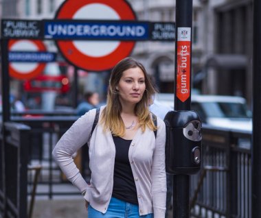 Genç kadın Londra metro istasyonunda bir fotoğraf için poz veriyor