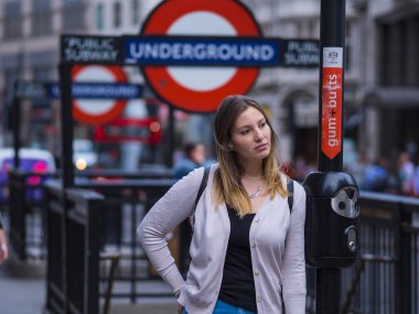 Kız bir Londra metro istasyonu girişinde rahatlatır