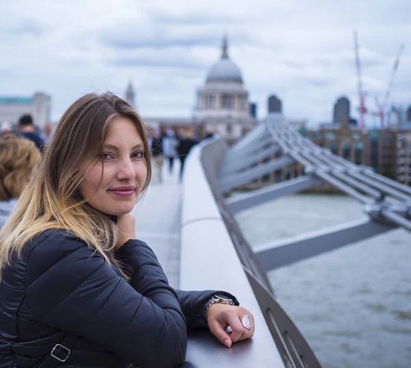 放松在泰晤士河畔的千年桥上的女孩 — 图库照片