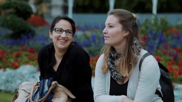 Dos mujeres jóvenes se relajan en un parque — Vídeos de Stock